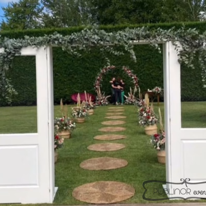Ceremonia de boda en jardín con puertas blancas, camino de piedras y arco de flores — Publinor Eventos, Ponferrada